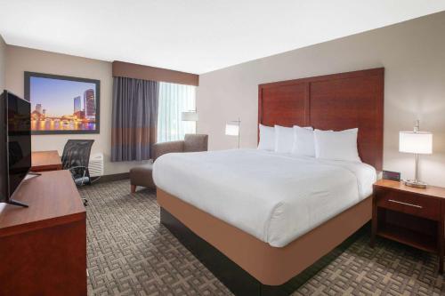 a hotel room with a large bed and a television at Baymont by Wyndham Grand Rapids Near Downtown in Grand Rapids