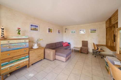 ein Wohnzimmer mit einem Sofa und einem Tisch in der Unterkunft Casa Aquarella - Proche Strasbourg in Schiltigheim