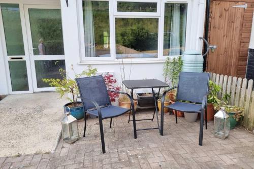 a group of chairs and a table in front of a house at Elgar Escape in Barnstaple