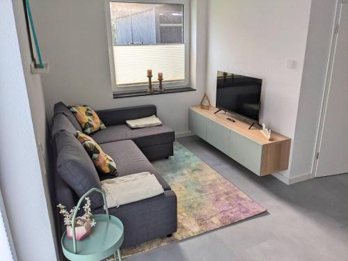 a living room with a couch and a television at Ferienwohnung direkt am Radweg zum Steinhuder Meer in Wunstorf