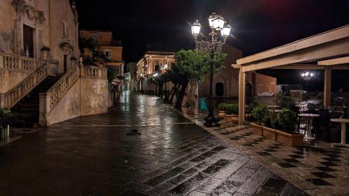 an empty street at night with a street light at Opuntia Charming Rooms in Taormina
