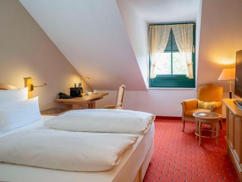 um quarto de hotel com uma cama e uma janela em Atomis Hotel Munich Airport by Mercure em Oberding