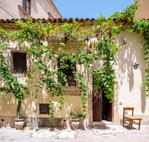 an old house with ivy on the side of it at Ziolì in Noto