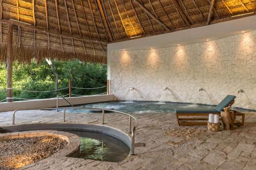 a swimming pool in a resort with a tub at Hyatt Zilara Riviera Maya Adults Only All-Inclusive in Playa del Carmen