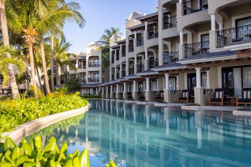 uma piscina num resort com palmeiras e edifícios em Hyatt Zilara Riviera Maya Adults Only All-Inclusive em Playa del Carmen