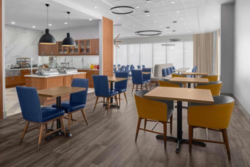 a restaurant with tables and chairs and a kitchen at Homewood Suites By Hilton Charlotte Uptown First Ward in Charlotte