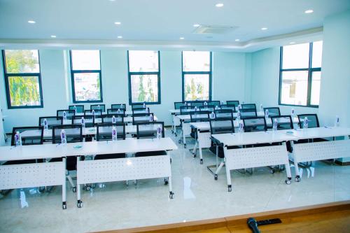a large room with tables and chairs and windows at Best Western Dodoma City Hotel in Dodoma