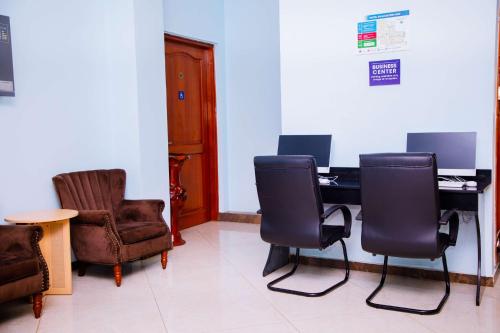 a waiting room with chairs and a desk with a computer at Best Western Dodoma City Hotel in Dodoma