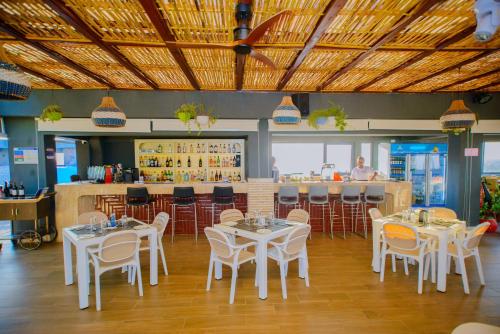 a restaurant with white tables and chairs and a bar at Best Western Dodoma City Hotel in Dodoma