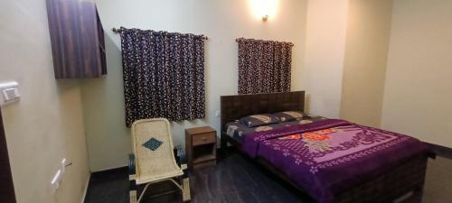 1 dormitorio con 1 cama de color púrpura y 1 silla en ASM Residency, en Kodaikanal