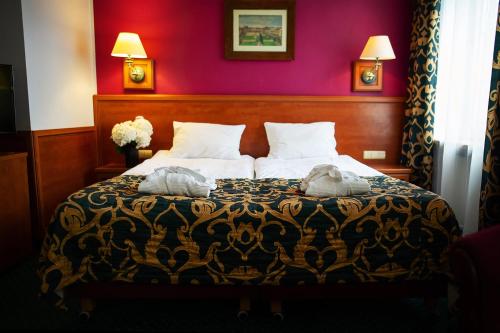 a bedroom with a bed with two towels on it at Pietrak Hotel in Gniezno