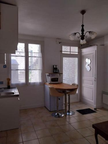 - une cuisine avec une table et un four micro-ondes dans l'établissement Cocon calme, 2 pièces Tours proche bord de Loire, à Tours