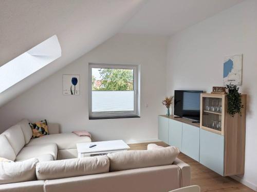 a white living room with a couch and a tv at Familienglück direkt am Radweg zum Steinhuder Meer in Wunstorf