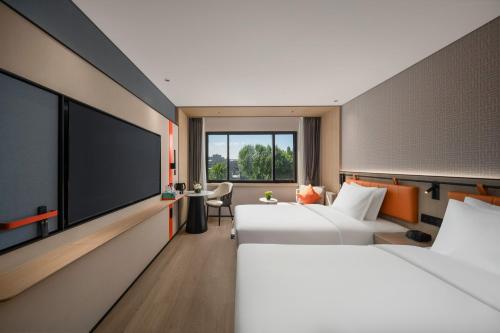 a hotel room with two beds and a flat screen tv at Holiday Inn Express Beijing Downtown, an IHG Hotel in Beijing