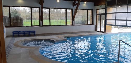 a large swimming pool with a large window at Charmant logement avec piscine in Bergerac