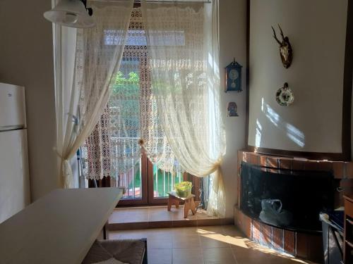 cocina con ventana grande con cortinas y chimenea en La casa nel borgo, en Forlì del Sannio