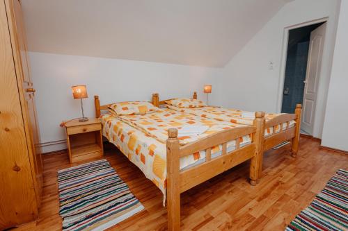 1 dormitorio con cama de madera y suelo de madera en Kaffai Panzio, en Izvoru Mureşului