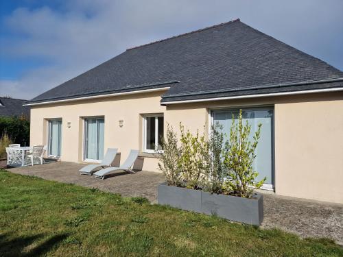Casa con 2 sillas y patio en Gîte de Kerninon Maison spacieuse et lumineuse, en Ploulech