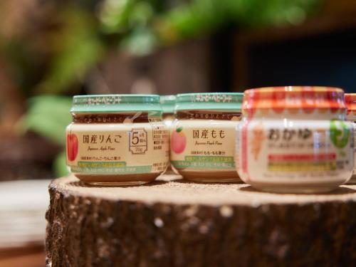 three jars of honey sitting on top of a tree stump at TOKYO EAST SIDE HOTEL KAIE in Tokyo