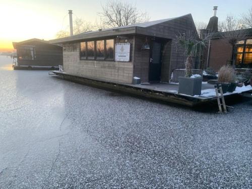 a building with a lot of water in front of it at Aangenaam op de Rijn, woonboot, inclusief privé sauna in Alphen aan den Rijn