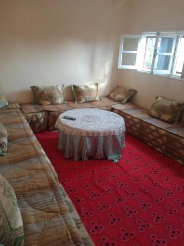 a room with a couch and a table on a red rug at Appartement au centre ville in Beni Mellal