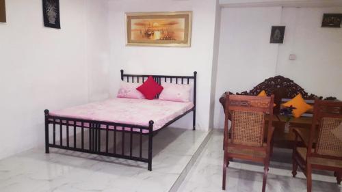 a bedroom with a crib with pink pillows on it at Beehive Colombo in Colombo