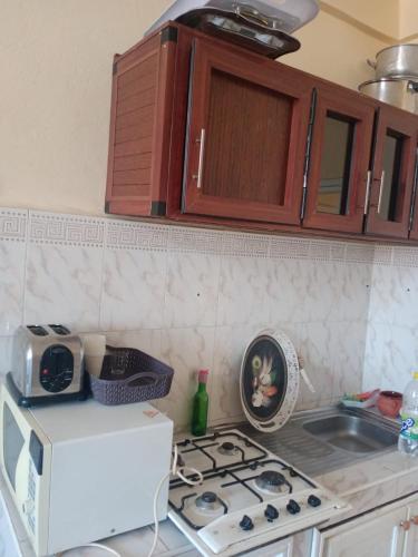 a kitchen with a stove top oven next to a microwave at Appartement au centre ville in Beni Mellal