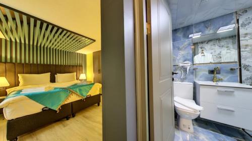 a bedroom with a bed and a bathroom with a sink at Wonder Wood Hotel in Istanbul