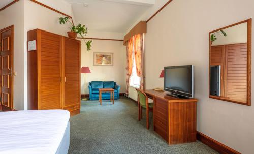 a bedroom with a bed and a tv on a desk at Hotel Victoria in Pärnu