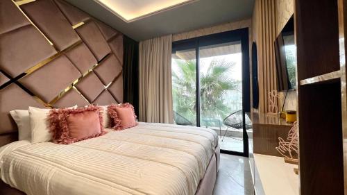 a bedroom with a large bed with pink pillows at The Address - Sunny Anfa Hills in Casablanca