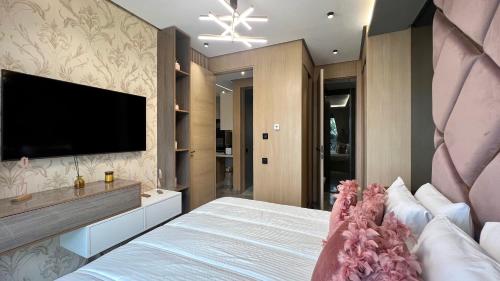 a bedroom with a large bed with a flat screen tv at The Address - Sunny Anfa Hills in Casablanca