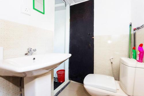 a white bathroom with a sink and a toilet at Beehive Colombo in Colombo