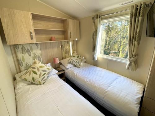two beds in a small room with a window at Pass the Keys Gorgeous Home in Beautiful Kippford Country Park in Dalbeattie