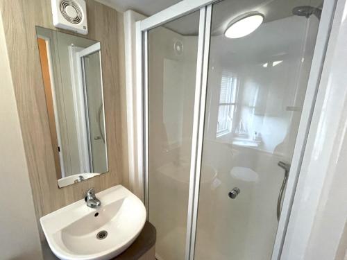 a bathroom with a white sink and a shower at Pass the Keys Gorgeous Home in Beautiful Kippford Country Park in Dalbeattie