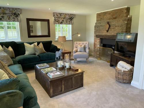 a living room with a couch and a tv at Cottage 2, Northbrook Park, Farnham-up to 6 adults in Farnham