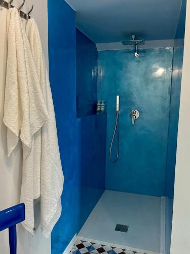 a bathroom with a shower with a blue wall at Casa Vacanze Penelope in Pizzo