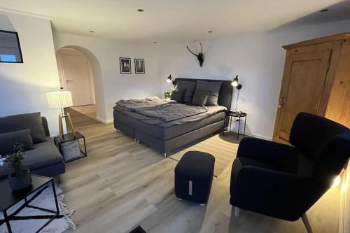 1 dormitorio con cama, sofá y sillas en Appartement Eifelglück, en Pelm