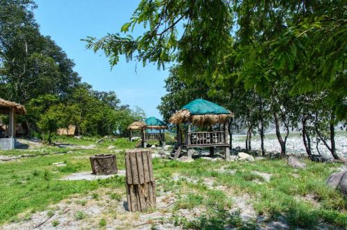 a group of gazebos with grass roofs at Beyond Brahmaputra & Eagles Nest in Brahmakund