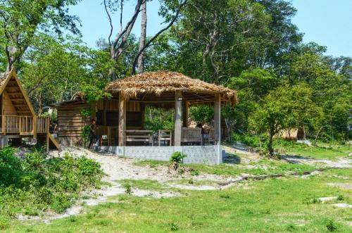 a log cabin with a thatched roof at Beyond Brahmaputra & Eagles Nest 