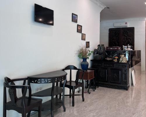 a dining room with a table and chairs and a tv at Srg Indira Hotel in Gelang Patah