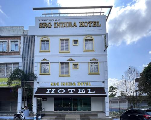 a white building with a sign for a hotel at Srg Indira Hotel in Gelang Patah