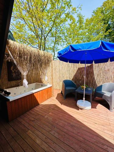 bañera de hidromasaje y sombrilla en la cubierta en Estebe Bungalov, en Sapanca