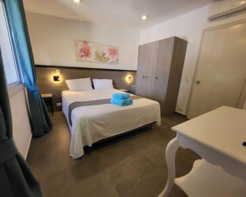 a hotel room with two beds with a blue towel on it at Hotel Oasis-Dream Holidays - La Petite France in San Bernardino