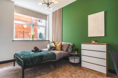 a bedroom with a bed and a green wall at Dreamy Derby City Apartment Free Wi-Fi & Parking in Derby