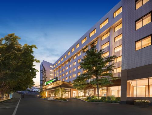 a large building with a tree in front of it at Holiday Inn Express Beijing Downtown by IHG in Beijing