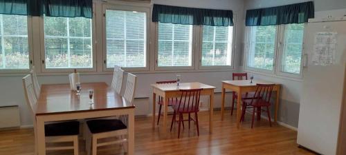 a room with two tables and chairs and windows at FolkiaCenter Gästhem - Vieraskoti - Guesthouse in Hanko