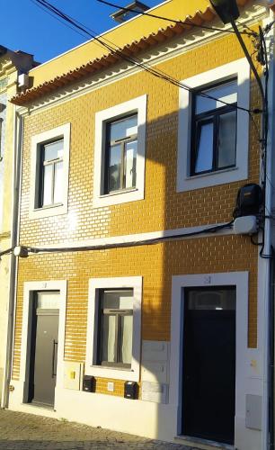a brick building with two garage doors on a street at Alojamento da Joana in Aveiro