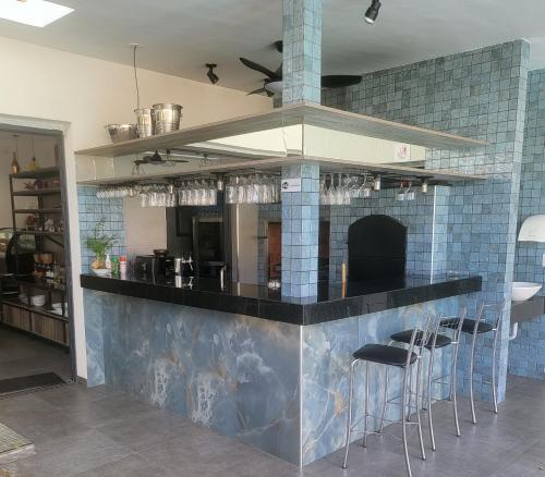 a kitchen with a blue tiled counter with stools at Hotel Oasis-Dream Holidays - La Petite France in San Bernardino