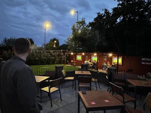 a man standing in front of a patio with tables and chairs at The Ivy Tree in Stockton-on-Tees