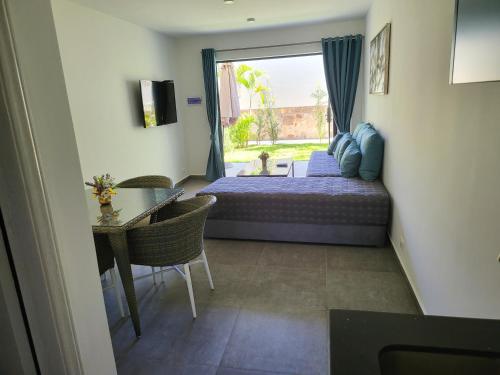 a bedroom with a bed and a table and a window at Hotel Oasis-Dream Holidays - La Petite France in San Bernardino